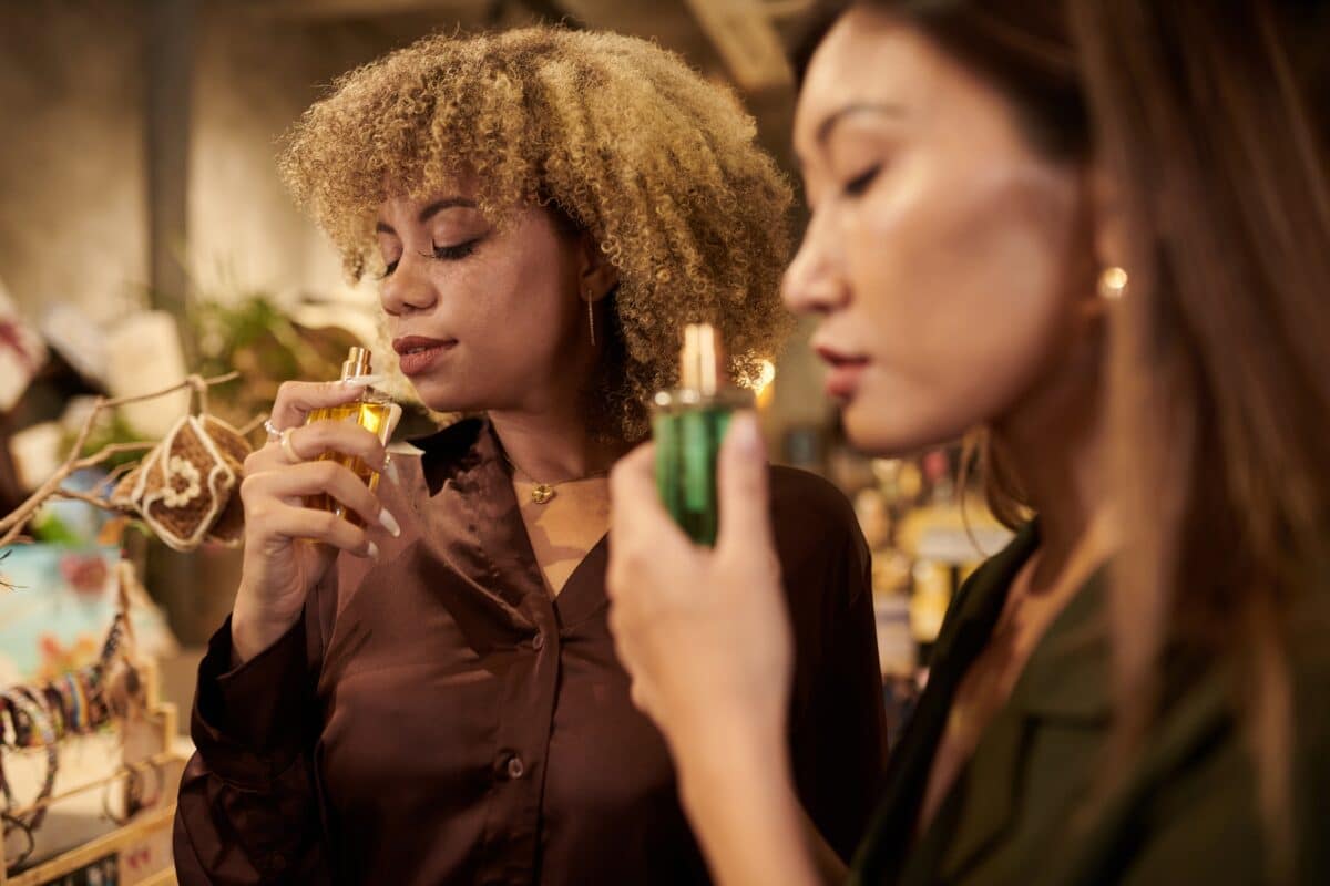 Two,Beautiful,Women,Smelling,Perfume,During,Shopping,At,Store