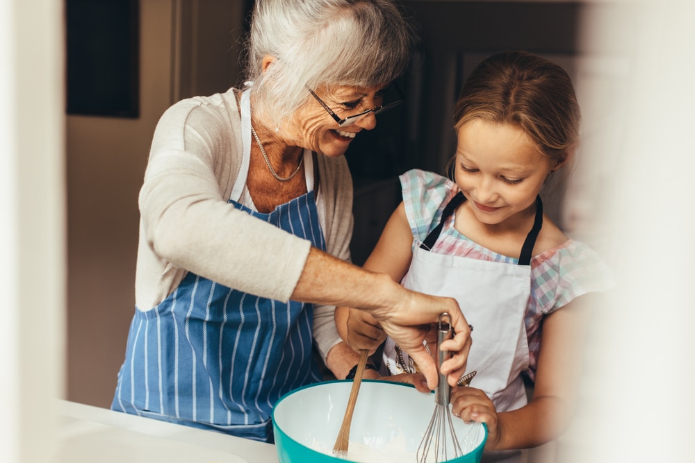 Senior,Woman,Teaching,A,Kid,To,Make,Batter,For,Cake