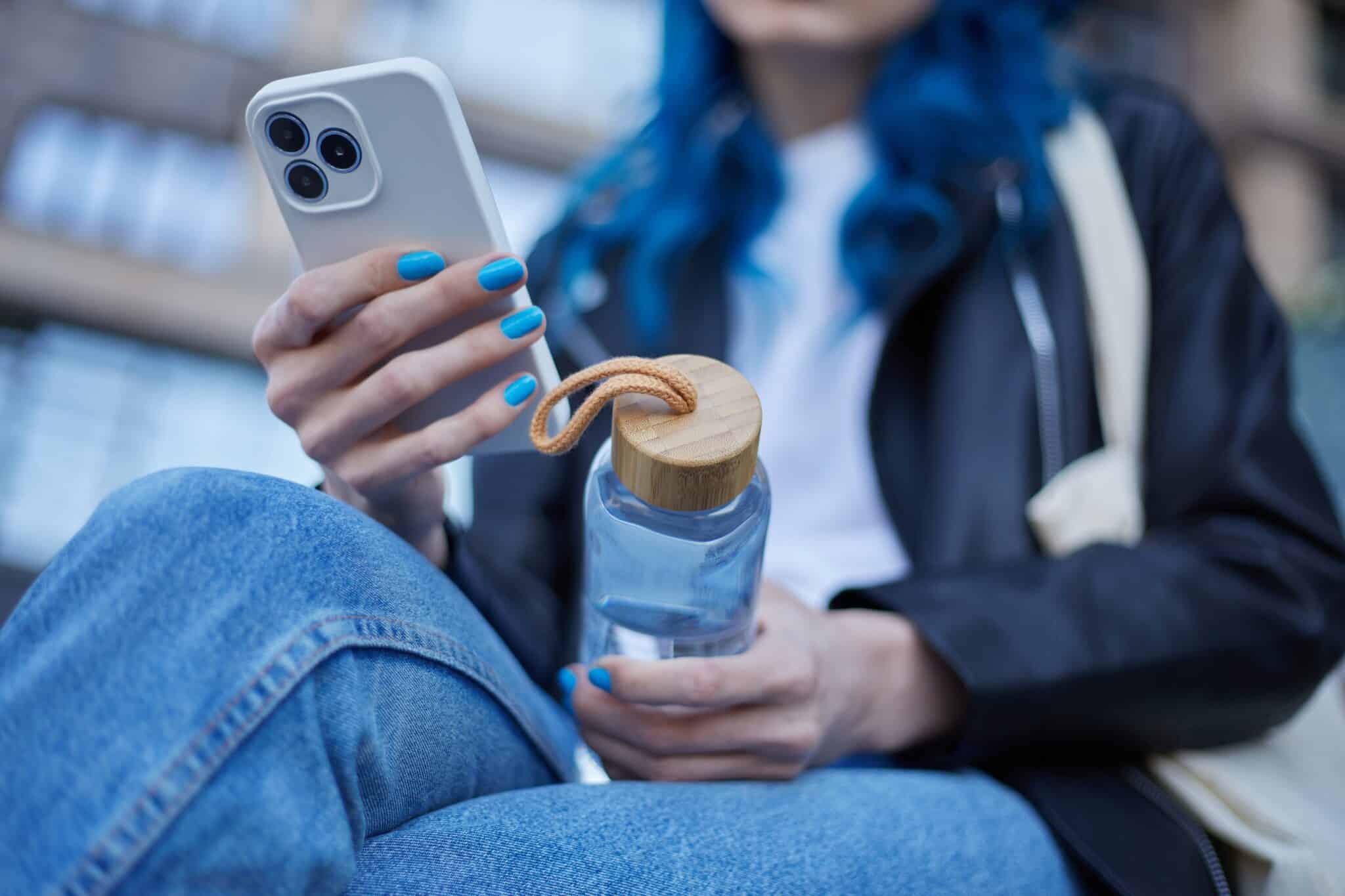 Young,Woman,Holding,A,Glass,Water,Bottle,In,Hands,While