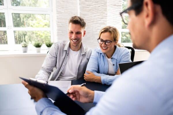 Financial,Consultant,Explaining,New,Project,Investment,To,Young,Couple,In