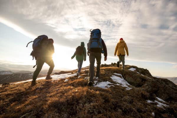 Group,Of,Four,Hikers,With,Backpacks,Walks,In,Mountains,At