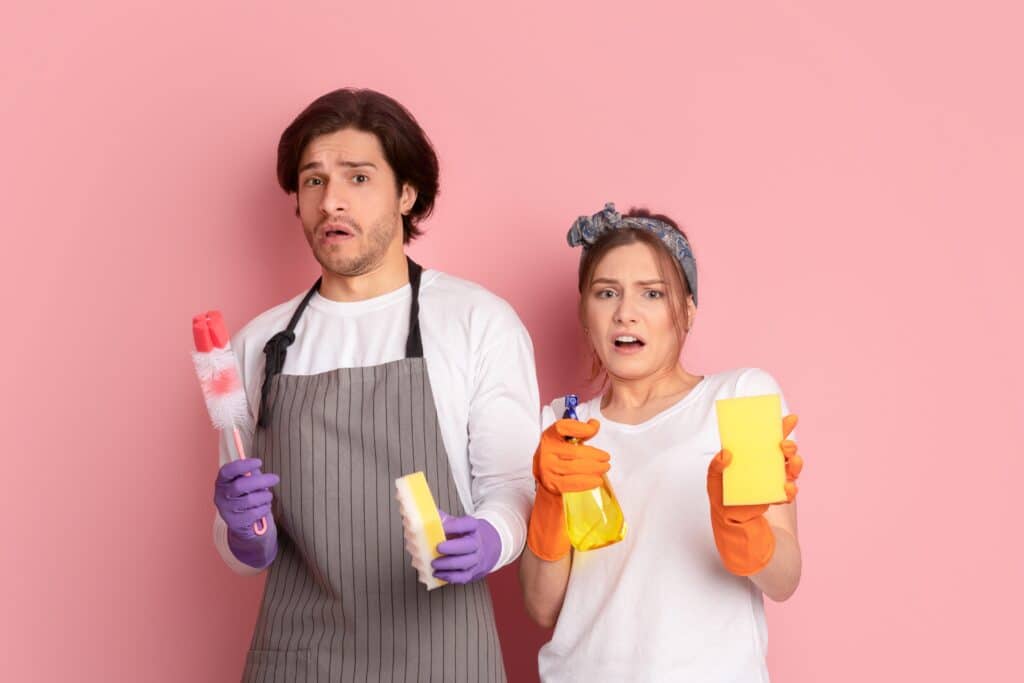 Young,Couple,With,Cleaning,Supplies,In,Hands,Looking,With,Disgust