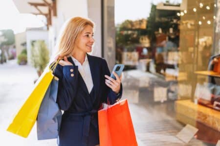 Woman,Holding,Shopping,Bags,And,Smartphone,Outside,Storefront ,Stylish,Woman