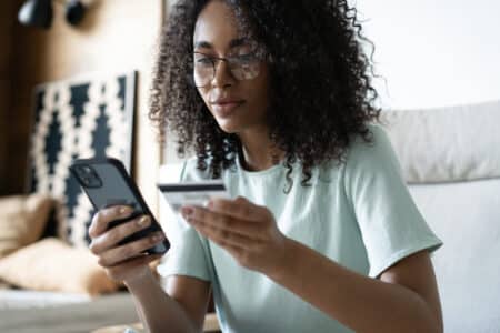 Happy,Millennial,Mixed,Race,Woman,Holding,Banking,Credit,Card,,Entering