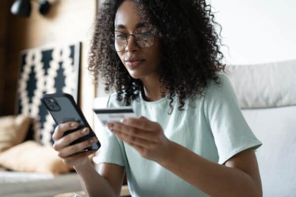 Happy,Millennial,Mixed,Race,Woman,Holding,Banking,Credit,Card,,Entering