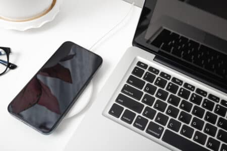 laptop phone and wireless charger on a white des utc