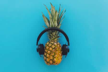 a pineapple listening to music with headphones utc