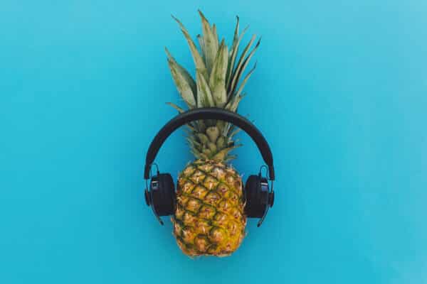 a pineapple listening to music with headphones utc