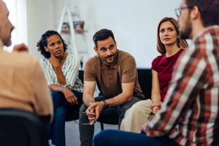 adults sit together indoors talking and listening utc