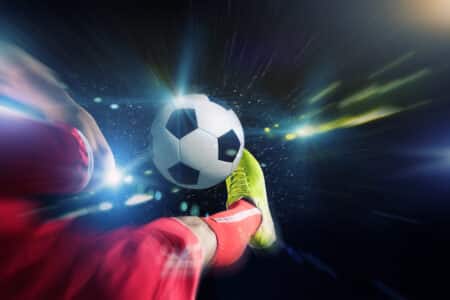 close up image of footballer foot kicking the ball utc